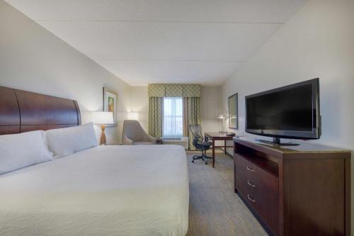 a hotel room with a bed and a flat screen tv at Hilton Garden Inn Durham Southpoint in Durham