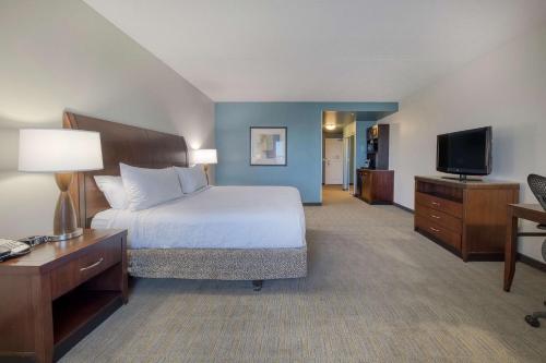 a hotel room with a bed and a television at Hilton Garden Inn Durham Southpoint in Durham