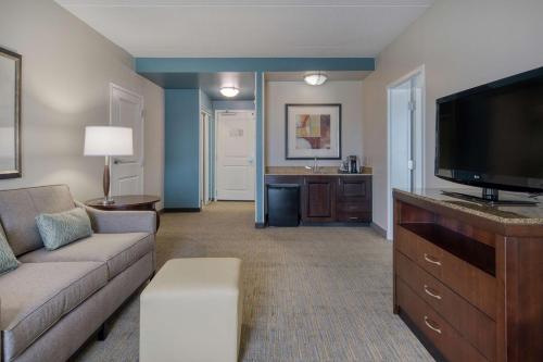 a living room with a couch and a flat screen tv at Hilton Garden Inn Durham Southpoint in Durham