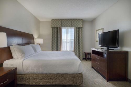 a hotel room with a bed and a flat screen tv at Hilton Garden Inn Durham Southpoint in Durham