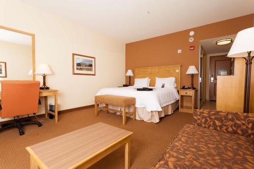 Habitación de hotel con cama y sofá en Hampton Inn & Suites Riverton, en Riverton