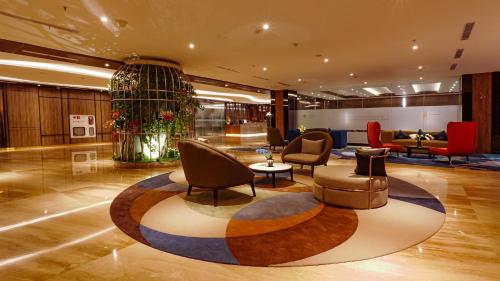 a lobby with chairs and a table in a building at FUGO Hotel Samarinda in Samarinda
