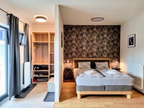 a bedroom with a bed and a wall at GRAND SPA Harrachov - Wellness luxusní apartmán s velkou vířivkou, saunou, kuchyní a venkovním posezením v centru Harrachova in Harrachov