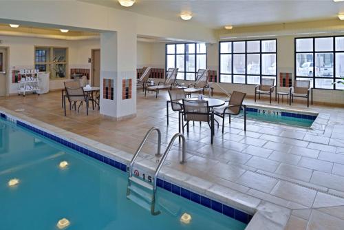 una piscina con mesas y sillas en un edificio en Hampton Inn Rock Springs en Rock Springs