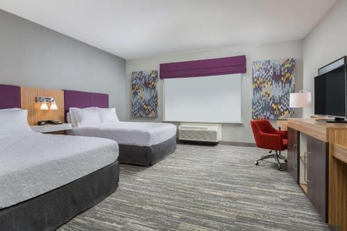 a hotel room with two beds and a flat screen tv at Hampton Inn & Suites Reno/Sparks in Reno
