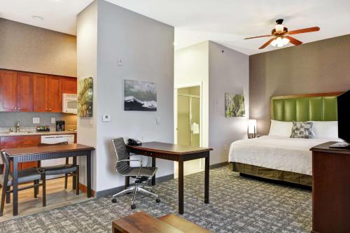 a bedroom with a bed and a desk and a kitchen at Homewood Suites by Hilton Reno in Reno