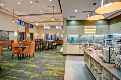 a restaurant with a cafeteria with tables and chairs at Homewood Suites by Hilton Christiansburg in Christiansburg