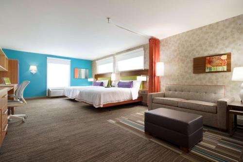 een hotelkamer met een bed en een bank bij Home2 Suites by Hilton Roanoke in Roanoke