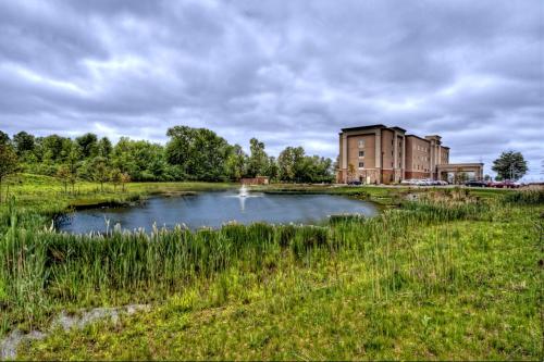 a pond in a field with a building in the background at Hampton Inn & Suites Rochester/Henrietta in Rochester