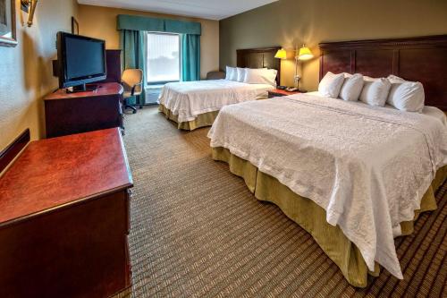 a hotel room with two beds and a flat screen tv at Hampton Inn Rochester - Irondequoit in Rochester