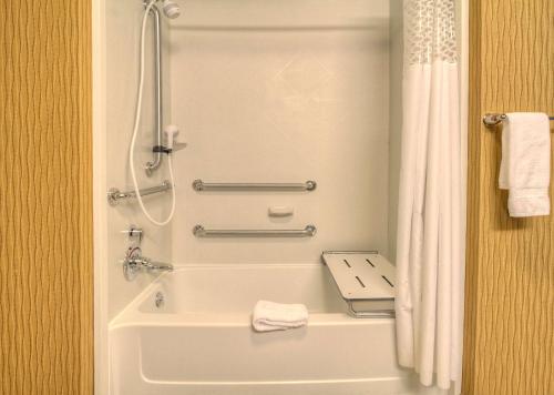 a bathroom with a shower and a bath tub at Hampton Inn & Suites Rochester/Henrietta in Rochester