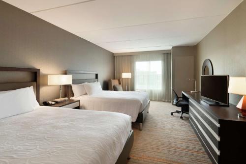 a hotel room with two beds and a flat screen tv at Hilton Garden Inn Rochester - University & Medical Center in Rochester