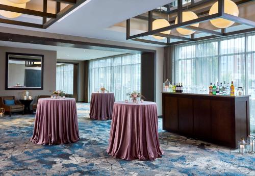 a hotel lobby with two tables and a bar at Hilton Garden Inn Rochester - University & Medical Center in Rochester