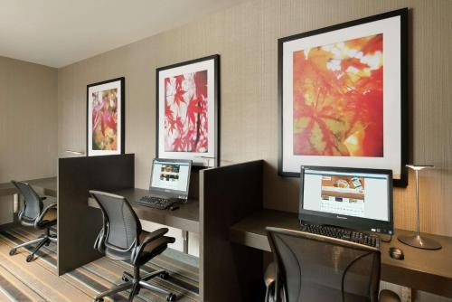 a room with four desks with computers and chairs at Hilton Garden Inn Rochester - University & Medical Center in Rochester