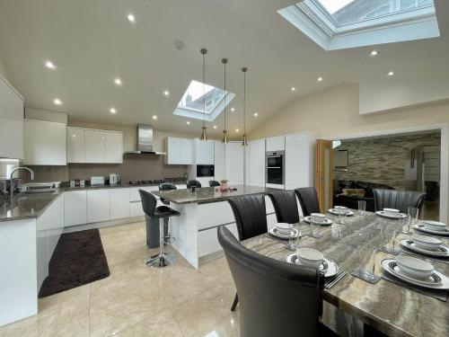 eine Küche und ein Esszimmer mit einem Tisch und Stühlen in der Unterkunft New Luxury Modern House near Airport Free Parking in Luton