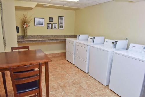 a laundry room with three washers and a table at Hampton Inn Ruston in Ruston