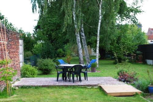 a patio with a table and chairs in a yard at Maison Coté Jardin Amiens - Longueau in Longueau