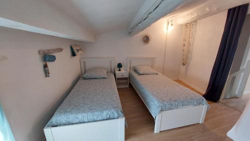 Cette petite chambre comprend 2 lits jumeaux. dans l'établissement Charmante maison au village, à Gruissan