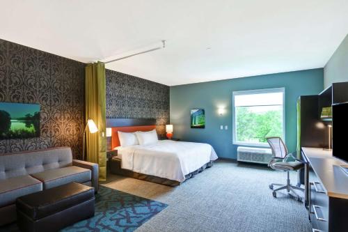 ロチェスターにあるHome2 Suites by Hilton Rochester Mayo Clinic Areaのベッドとソファ付きのホテルルーム