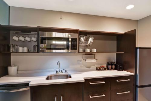 a kitchen with a sink and a microwave at Home2 Suites by Hilton Rochester Mayo Clinic Area in Rochester