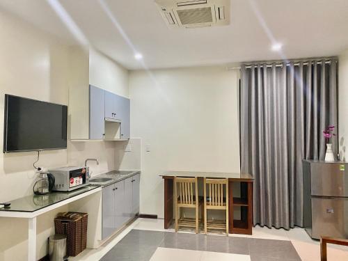 una cocina con mesa y TV. en In Le Hotel & Apartments, en Hai Phong