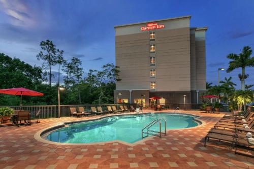 a pool in front of a hotel building at Hilton Garden Inn Fort Myers Airport/FGCU in Fort Myers