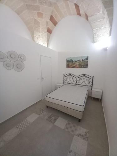 1 dormitorio con 1 cama en una habitación blanca en Giura, en Lecce