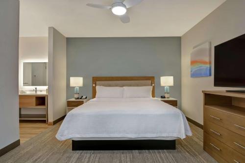 a bedroom with a large bed and a flat screen tv at Homewood Suites By Hilton Chula Vista Eastlake in Chula Vista