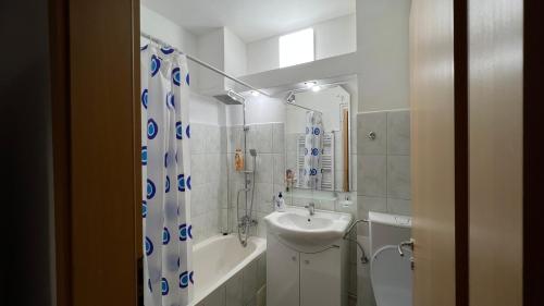 a bathroom with a sink and a shower curtain at MarioApartCentralView in Timişoara