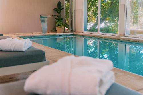 a room with a swimming pool with a bed and windows at Hostería & Spa De La Cascada in Tandil