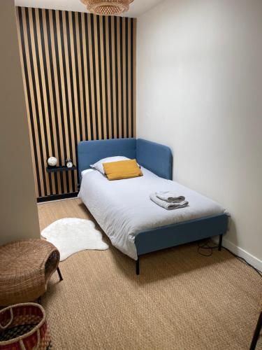 um quarto com uma cama com uma cabeceira azul em Le loft du chapitre em Saint-Brieuc