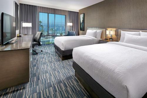 um quarto de hotel com duas camas e uma televisão de ecrã plano em Hilton Garden Inn San Diego Downtown/Bayside, CA em San Diego