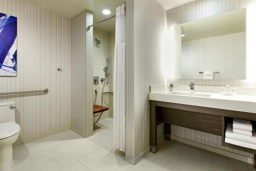 a bathroom with a sink and a toilet and a mirror at Hilton Garden Inn San Diego Downtown/Bayside, CA in San Diego