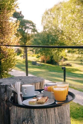 a tray with food and drinks on a table at Hostería & Spa De La Cascada in Tandil