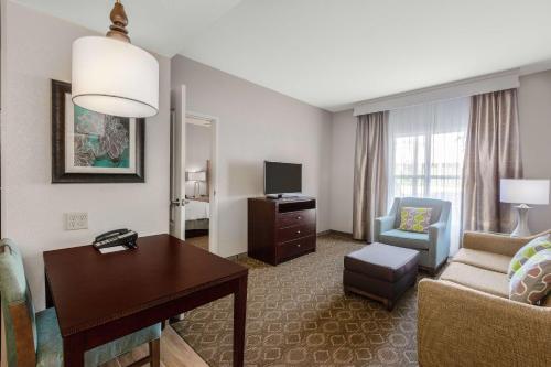 a hotel room with a desk and a living room at Homewood Suites by Hilton Carlsbad-North San Diego County in Carlsbad