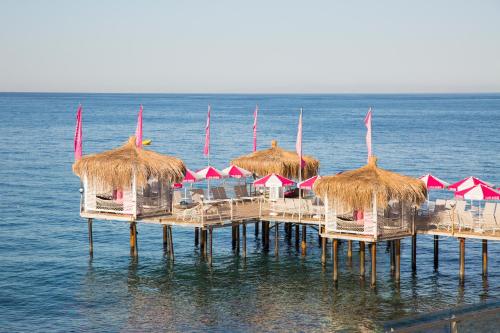 a group of umbrellas and chairs on a pier in the water at Club Hotel Anjeliq in Alanya