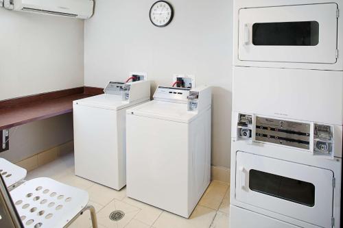 a kitchen with white appliances and a clock on the wall at Homewood Suites by Hilton Carlsbad-North San Diego County in Carlsbad