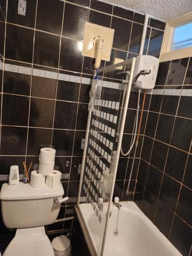 een badkamer met een toilet en een bad bij A cosy 1 bedroom apartment in Enfield