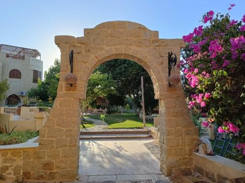 an archway in a yard with flowers at palm shadow resort in Tunis