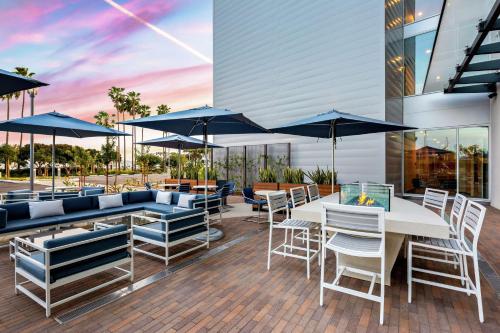 a patio with tables and chairs and umbrellas at Hampton Inn & Suites San Diego Airport Liberty Station in San Diego