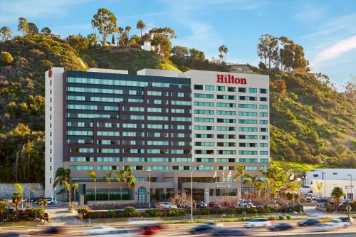 a hotel building with a hill in the background at Hilton San Diego Mission Valley in San Diego