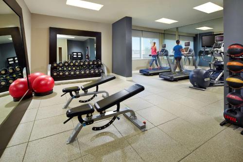 a gym with exercise equipment and people in the background at Hilton San Diego Mission Valley in San Diego