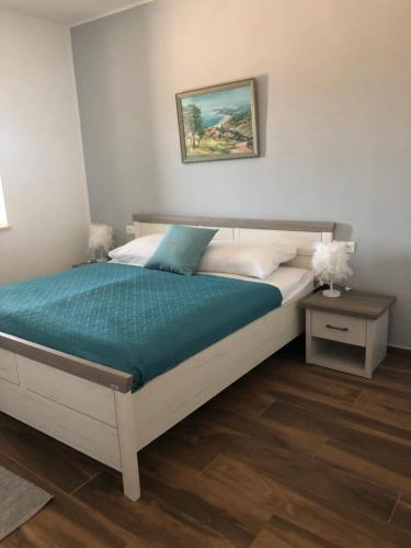 - une chambre avec un grand lit et une couverture verte dans l'établissement Ferienhaus Luisa Insel Brac - Kamin, Pool, Grill, Olivengrundstück, à Pučišća