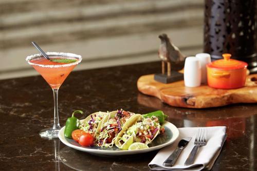 a table with a plate of food and a drink at Hilton Garden Inn San Diego Mission Valley/Stadium in San Diego