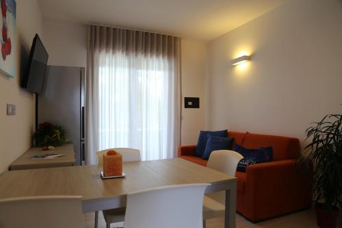 a living room with a table and a couch at Villaggio Mare Blu in Bibione