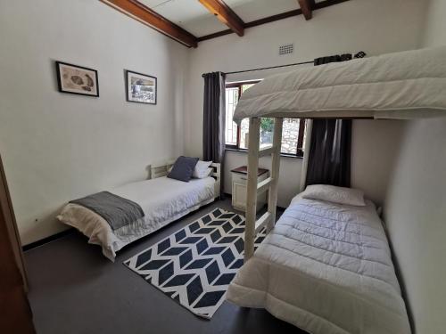 a bedroom with two beds and a bunk bed at Oceanscape in Bettyʼs Bay