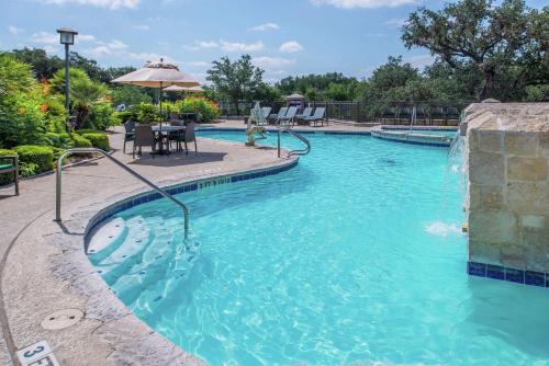 a swimming pool with a water feature in a resort at Hilton San Antonio Hill Country in San Antonio