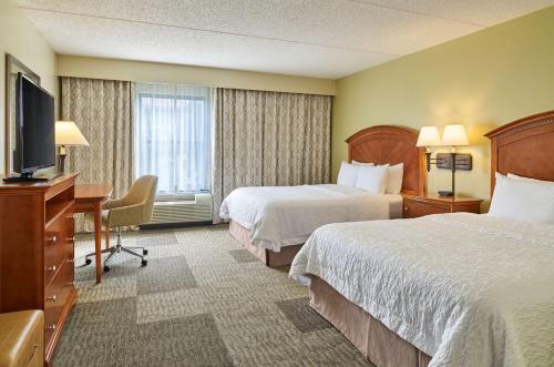 Habitación de hotel con 2 camas, escritorio y TV. en Hampton Inn San Antonio Stone Oak en San Antonio