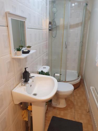 a bathroom with a sink and a shower and a toilet at Cozy bedroom C in London