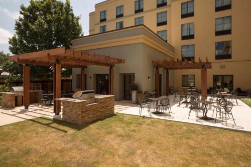 a patio with a grill and tables and chairs in front of a building at Homewood Suites by Hilton San Antonio North in San Antonio